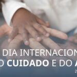 Mãos sobrepostas de uma criança negra, uma mulher branca, um homem negro. Dia Internacional do Cuidado e do Apoio. 29 outubro 2024.