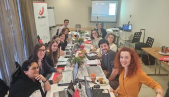 Fotografia dos participantes na mesa de reuniõe